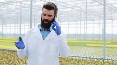 Konuşmak Smartphone kullanarak bir sera içinde ziraat mühendisi telefon,
