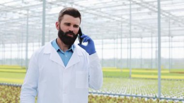 Konuşmak Smartphone kullanarak bir sera içinde ziraat mühendisi telefon,