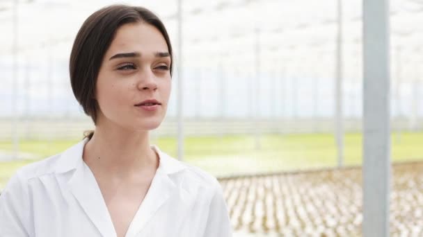 Man and woman in laboratory robes talk to each other standing in the greenhouse — Stock Video