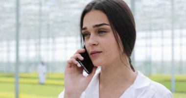 Telefon standinh sera içinde araştırmacı görüşmeler. Serada çalışan ziraat mühendisi