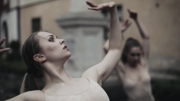 Jóvenes bailarinas profesionales están realizando danza acrobática a lo largo de la calle medieval bajo la lluvia. Chicas mojadas bailando en gotas de agua, cámara lenta — Vídeos de Stock