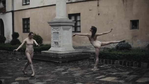 Fiatal női táncosok akrobatikus tánc alá eső középkori utcán végzi. Nedves lányok tánc vízcseppek, lassú mozgás — Stock videók