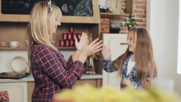 Charmante moeder en dochter have fun in een gezellige keuken — Stockvideo