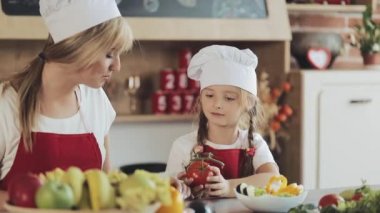 Anne ve küçük kızı mutfakta yemek: Onlar taze bir bahçe salata ve anne kız öğretir. Pişirme ve mutlu aile kavramı
