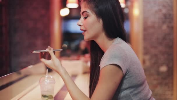 Mulher bonita no bar da noite falando com smartphone, ouvindo mensagem de voz. Mulher desfrutando da vida noturna enquanto se comunica com amigos em seu smartphone — Vídeo de Stock