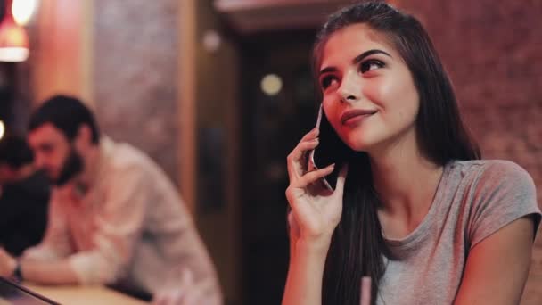 Νεαρή Όμορφη Γυναίκα Μιλώντας Στο Τηλέφωνό Της Ένα Μπαρ Κάθεται — Αρχείο Βίντεο