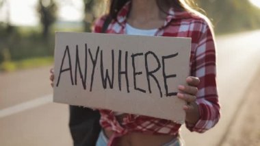 Herhangi bir yeri işaret tutan yolda otostop kalan genç güzel kadın. Yaz saati