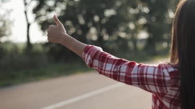 Womaan kal Road başparmak yukarı yaz güneşli bir günde. Yakın çekim. Otostop. Gezgin. Ulaşım