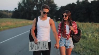 Yolda otostop ve macera işaret tutan tatile çift. Yaz saati. Kavramı, turistler, otostop Maceraları