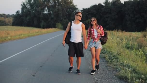 Couple On Vacation Hitchhiking Along Road and Holding Anywhere Sign. Summer time. Hitchhiking, tourists, adventures concept — Stock Video