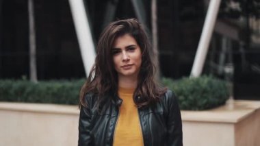 Modern sokakta duran çekici kadın portresi. Gülümseyen kadın. Siyah deri ceket.