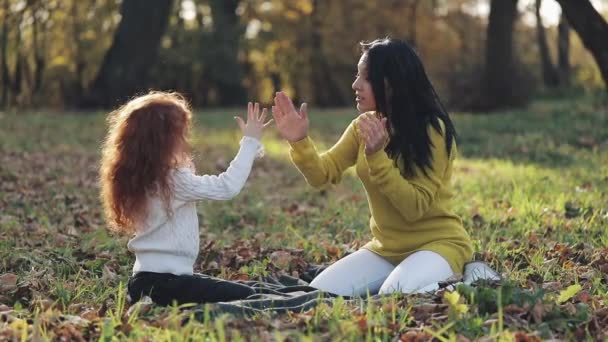 Mamma e figlia giocano con le mani. Famiglia felice nel parco autunnale — Video Stock