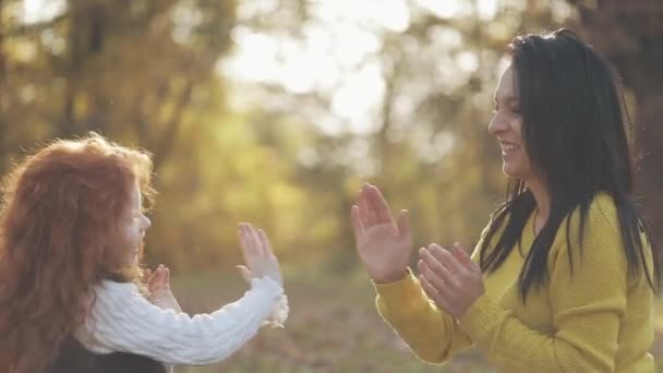 Moeder en dochter handen spelen. Gelukkige familie in herfst park — Stockvideo