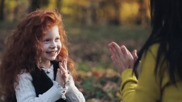 Mama i córka ręce grać. Szczęśliwa rodzina w jesienny park — Wideo stockowe