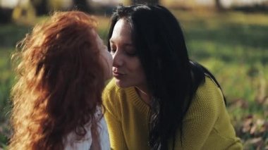 Anne ve kızı sonbahar park, yeme, gülerek ve gülümseyerek oynuyorlar. ağır çekim