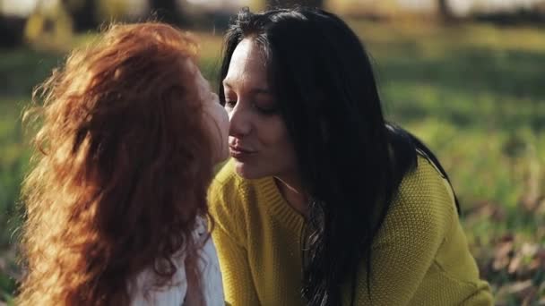 Mamá y su hija jugando en el parque de otoño, Comen, riendo y sonriendo. cámara lenta — Vídeos de Stock