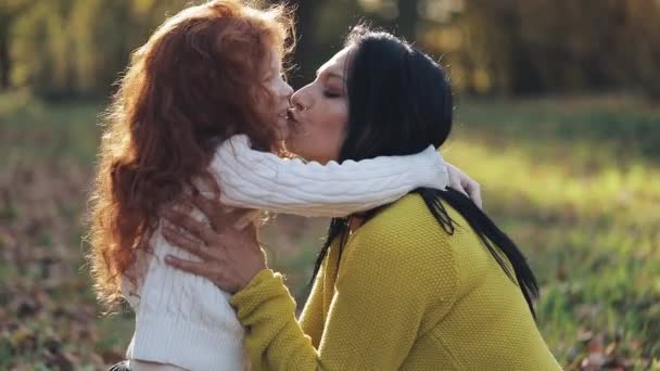 Mamá y su hija jugando en el parque de otoño, Comen, riendo y sonriendo. cámara lenta — Vídeos de Stock