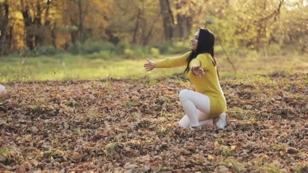 Nettes kleines Mädchen, das seine Mutter im Herbstpark umarmt. Glückliches Familienkonzept — Stockvideo