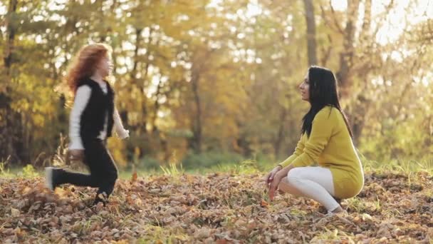 Linda niña abrazando a su madre en el parque de otoño. Concepto de familia feliz — Vídeos de Stock