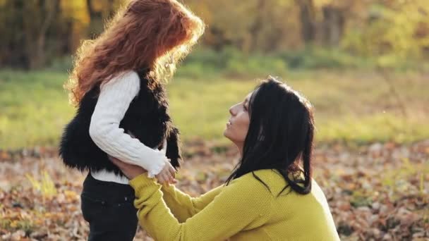 Szczęśliwa młoda matka i jej córeczka rude, zabawy w parku jesień. Ich gra, Całowanie, przytulanie i śmiejąc się. Zwolnionym tempie — Wideo stockowe