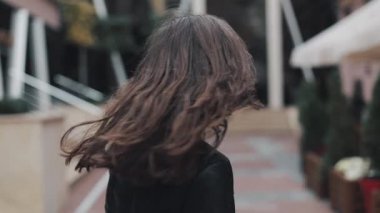 Modern bir binada yakınındaki sokakta yürüyen iki kez güzel bir gülümseme ile kameraya dönüm genç çekici kadın