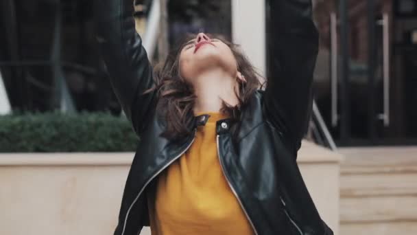 Fröhliche junge Frau, die auf die Straße geht und sich tanzend bewegt. Zeitlupe — Stockvideo