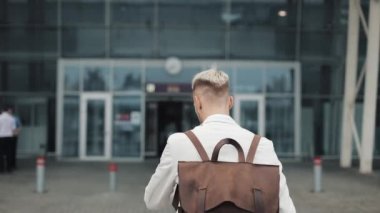 İş yerinde iş adamı. Yakışıklı delikanlı havaalanına sırt çantası ile çalışan ve bitime seyir beyaz gömlekli. Seyahat, Toplantı, iş geç kavramı olmak