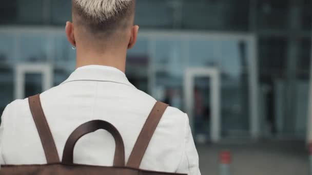 İş yerinde iş adamı. Beyaz gömlekli sırt çantası ile Havaalanı'na gidiş ve saati görünümlü yakışıklı genç adam. Seyahat, iş toplantısı, havaalanında, kalkış kavramı Toplantı — Stok video