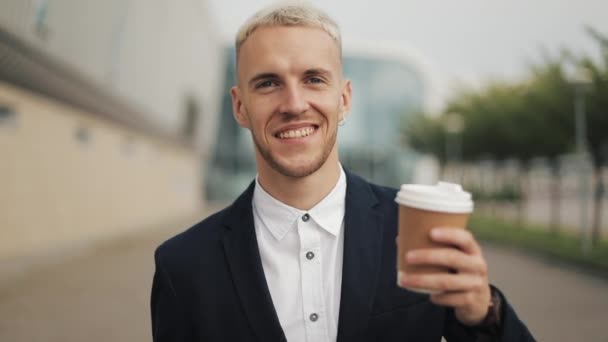 Portret van een jonge man met koffie op zoek naar de camera. Vrolijk portret van succesvolle business man uitvoerende professional lachen — Stockvideo