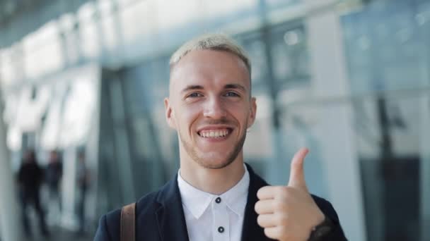 Thumbs Up van jonge aantrekkelijke zakenman buiten kantoor. Gelukkig Man Standing in de buurt van de luchthaven en in de Camera kijken — Stockvideo