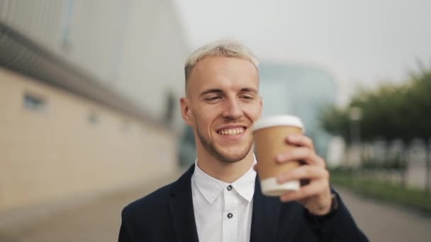 Portrét mladého obchodníka s kávou, při pohledu do kamery a pít teplý nápoj. Směje se veselý portrét úspěšné obchodní muž výkonné Professional — Stock video