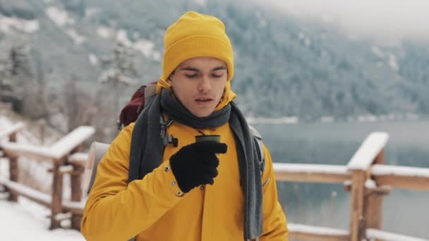 Prachtige bergen in de winter. Wandelaar man met gele winterkleren wandelen en het drinken van hete thee of koffie buiten in de koude tijd — Stockvideo