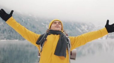 Dağın tepesinde duran genç uzun yürüyüşe çıkan kimse adam. Gezgin adam ellerini yükselterek. Başarılı ve kazanan kavram. Kış saati