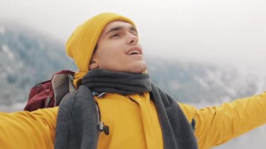 Dağın tepesinde duran genç uzun yürüyüşe çıkan kimse adam. Gezgin adam ellerini yükselterek. Başarılı ve kazanan kavram. Kış saati