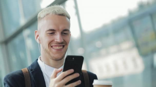 Jeune Homme Attrayant Marche Dans Rue Tenant Café Utilisant Téléphone — Video