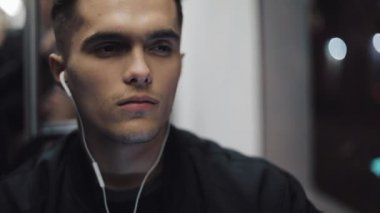 Akşamları, müzik dinlemek o toplu taşıma sürme ve tren pencereden dışarı bakıyor yorgun üzgün bir adam. Ağır çekim