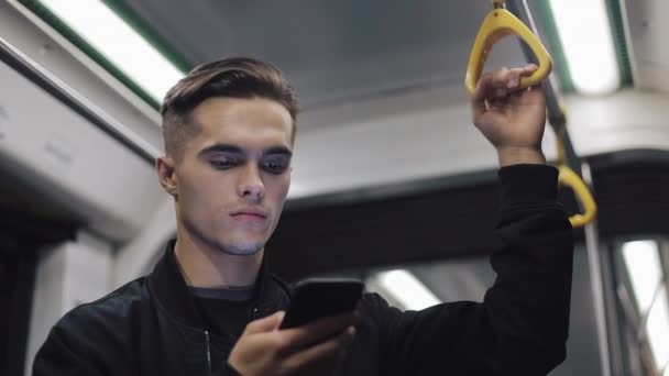 Портрет серьезного человека держит перила просмотра смартфона в общественном транспорте — стоковое видео