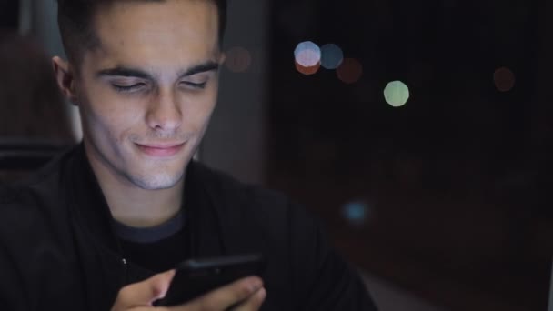 Glücklicher junger Mann mit Smartphone während der Straßenbahnfahrt, Steadicam-Aufnahme. Zeitlupe — Stockvideo