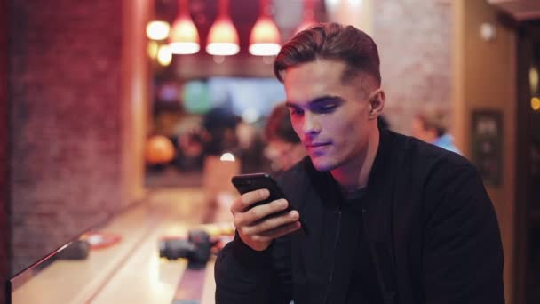 Joven Hombre Atractivo Con Hermosa Sonrisa Está Utilizando Teléfono Inteligente — Vídeo de stock