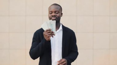 Ayakta paralarını gösterilen çevre ofis dışında Afrikalı-Amerikalı işadamı portresi. İş, insanlar, mali ve kolay para kavramı