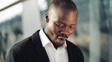 Cep telefonu görünümlü ve para büyük bir miktar onun elinde tutan kutluyor tezahürat mutlu Afrika kökenli Amerikalı iş adamı. Ofis merkezi veya banka yakınlarında sokakta duruyor