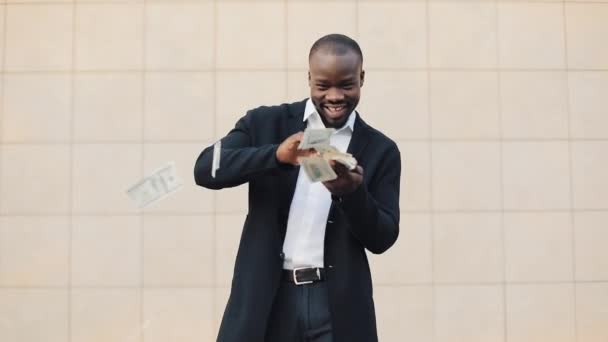 Heureux, homme d'affaires afro-américain réussi jetant de l'argent à la caméra. Pluie d'argent, chute de dollars. Au ralenti. Une entreprise prospère — Video