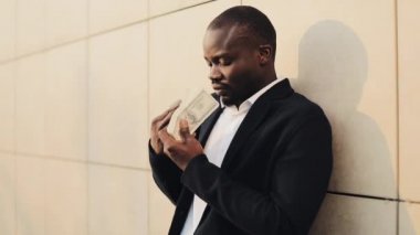 Afrika kökenli Amerikalı işadamı para ile. Parayla mutlu başarılı bir adamdır. Para kokusu. Zengin bir adam para dolanıyor. Başarılı iş