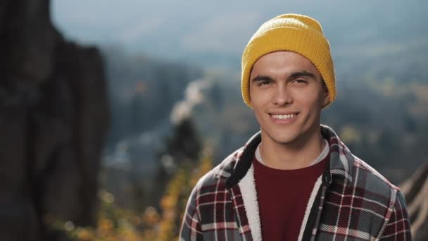 若いハイカー男山に立って カメラに笑顔の肖像画 美しい岩の背景 アウトドア — ストック動画