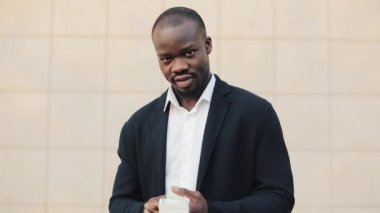 Office merkezine yakın para ayakta sayma takım elbiseli Afrikalı-Amerikalı işadamı portresi. O onun başarılı kazanmak dolar bir çok ile kutluyor ve kameraya bakıyor.