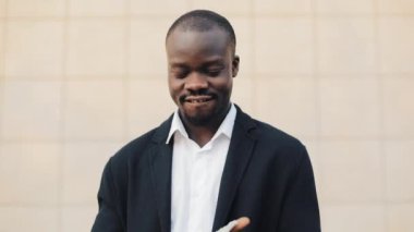Büyük miktarda para onun elinde tutan mutlu Afrika kökenli Amerikalı iş adamı. O ofis merkezi veya banka yakınlarında sokakta duruyor ve para için kamera gösterir