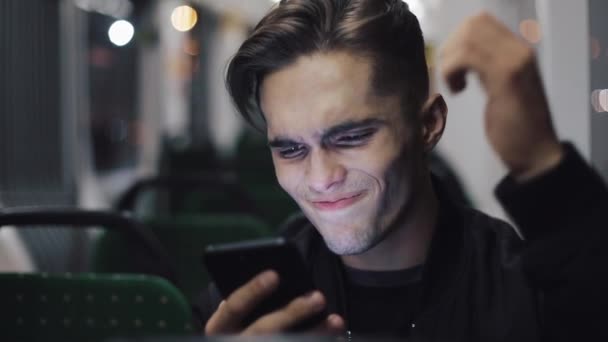 不快乐的年轻商人用智能手机阅读公共交通中的坏消息 — 图库视频影像
