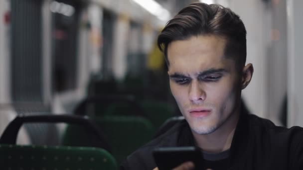 Unglücklicher junger Geschäftsmann mit Smartphone beim Lesen schlechter Nachrichten in öffentlichen Verkehrsmitteln — Stockvideo