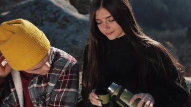 Termos dağ zemin üzerine birkaç aşk içecek çay üzerinden bir kupa. Taşlar üzerinde oturan ve güzel doğa üzerinde seyir turistler. Turizm, dinlenme, tatil, Doğa, zam kavramı