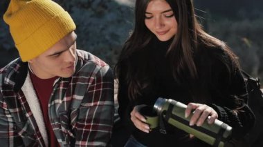 Termos dağ zemin üzerine birkaç aşk içecek çay üzerinden bir kupa. Taşlar üzerinde oturan ve güzel doğa üzerinde seyir turistler. Turizm, dinlenme, tatil, Doğa, zam kavramı